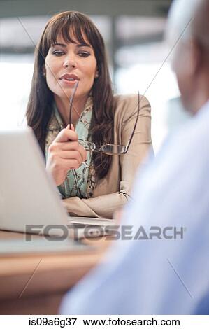 Businesswoman holding glasses using laptop View Large Photo Image Stock Photo - Businesswoman holding glasses using laptop. Fotosearch