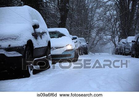 Stock Image - Cars parked in snow covered street. Fotosearch