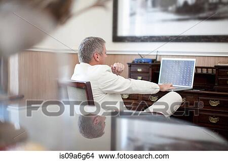Casual business man in hotel room using laptop View Large Photo Image Picture - Casual business man in hotel room using laptop. Fotosearch