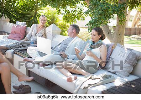 Casual business people on patio using laptop View Large Photo Image Stock Image - Casual business people on patio using laptop. Fotosearch