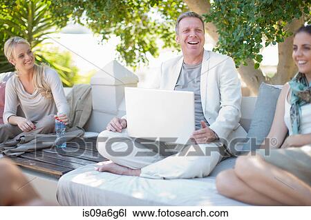 Casual business people on patio using laptop View Large Photo Image Stock Image - Casual business people on patio using laptop. Fotosearch