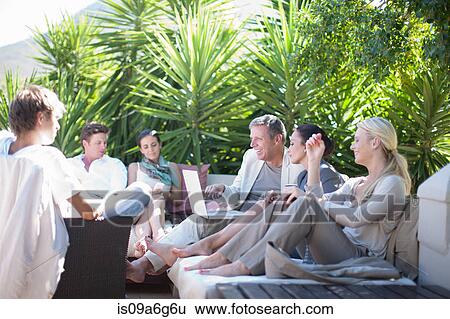 Casual business people on patio using laptop View Large Photo Image Stock Photograph - Casual business people on patio using laptop. Fotosearch