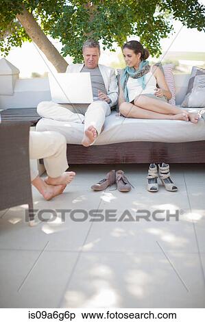 Casual business people on patio using laptop View Large Photo Image Stock Photography - Casual business people on patio using laptop. Fotosearch