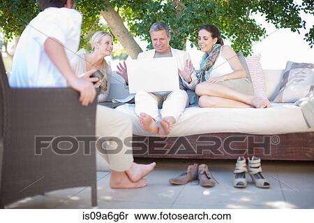 Casual business people on patio using laptop View Large Photo Image Stock Photography - Casual business people on patio using laptop. Fotosearch