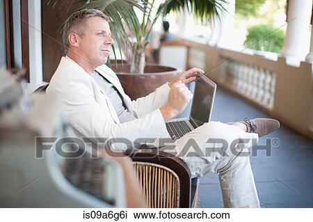 Casual businessman using laptop View Large Photo Image Stock Image - Casual businessman using laptop. Fotosearch