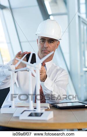 Stock Photo - Engineer photographing model wind turbines. Fotosearch