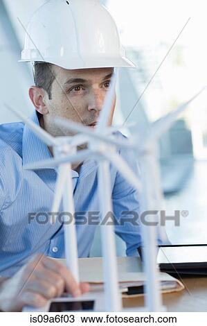 Stock Image - Engineer with model wind turbines. Fotosearch