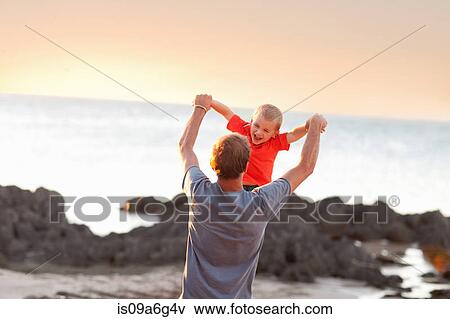 Father playing with son on beach View Large Photo Image Stock Photo - Father playing with son on beach. Fotosearch