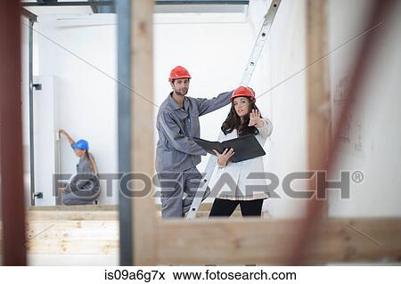 Female architect discusses plans with laborer on construction site View Large Photo Image Stock Photo - Female architect discusses plans with laborer on construction site. Fotosearch