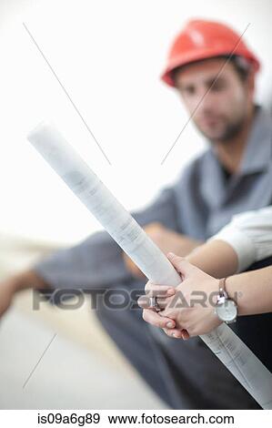 Stock Photo - Female architect holding blueprint. Fotosearch