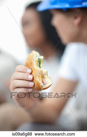 Female worker holding sandwich View Large Photo Image Stock Photo - Female worker holding sandwich. Fotosearch