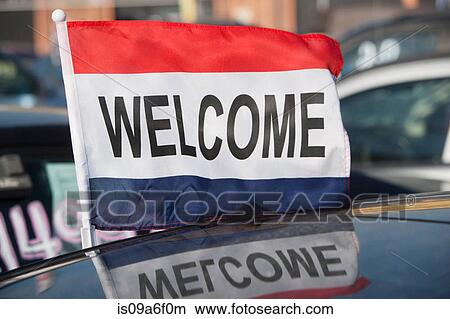 Picture - Flag saying Welcome at car dealership. Fotosearch