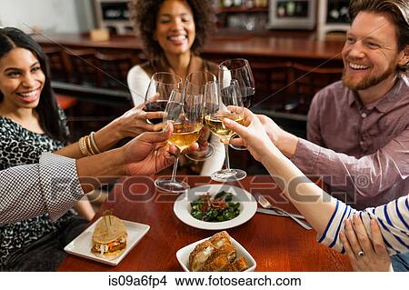 Picture - Friends at restaurant toasting. Fotosearch