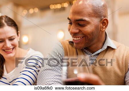 Stock Image - Friends looking down at something together. Fotosearch