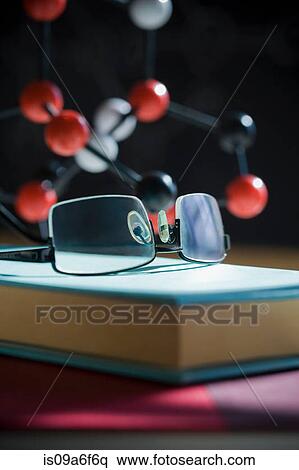 Stock Photography - Glasses and book with molecular model in background. Fotosearch
