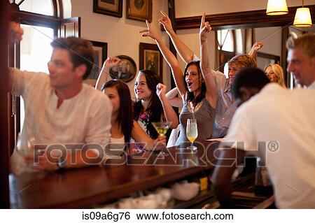 Group of young people cheering in bar View Large Photo Image Stock Photograph - Group of young people cheering in bar. Fotosearch