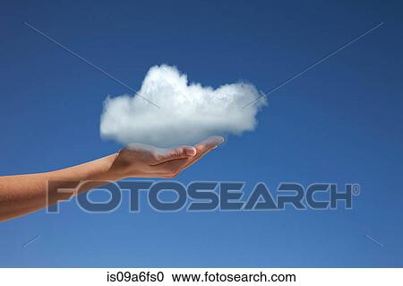 Stock Image - Hand holding cloud against blue sky. Fotosearch