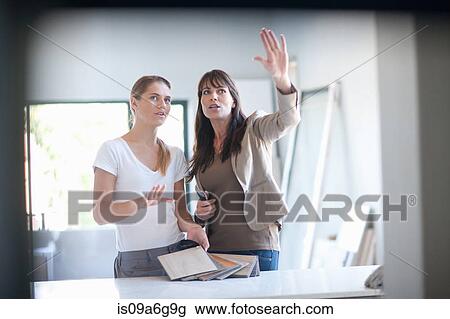 Stock Image - Interior designers discussing ideas. Fotosearch