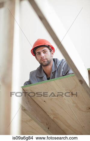 Laborer looking down from construction frame View Large Photo Image Picture - Laborer looking down from construction frame. Fotosearch