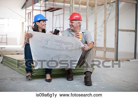 Male and female construction workers sitting down holding coffee and a blueprint View Large Photo Image Stock Photo - Male and female construction workers sitting down holding coffee and a blueprint. Fotosearch