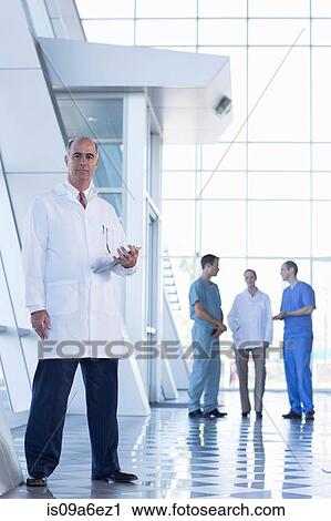 Stock Image - Male doctor holding medical records. Fotosearch