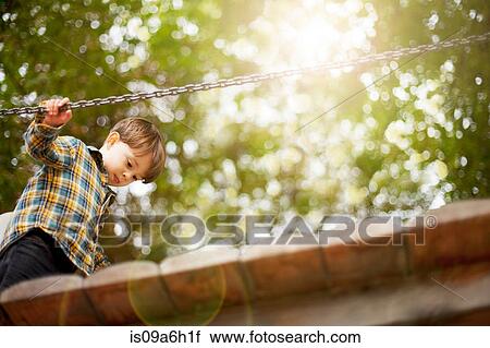 Stock Image - Male toddler crossing wooden footbridge. Fotosearch
