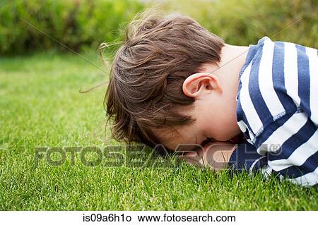 Male toddler hiding face down on grass View Large Photo Image Picture - Male toddler hiding face down on grass. Fotosearch