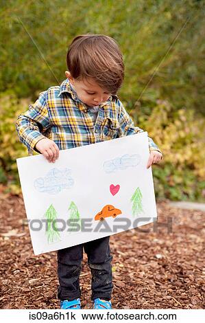 Stock Image - Male toddler holding crayon drawing. Fotosearch