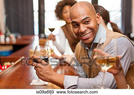Man enjoying glass of wine and chatting View Large Photo Image Stock Photo - Man enjoying glass of wine and chatting. Fotosearch