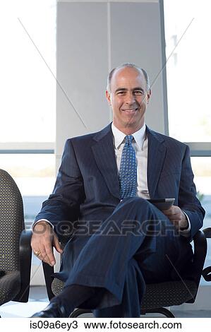 Mature businessman sitting in chair View Large Photo Image Stock Image - Mature businessman sitting in chair. Fotosearch