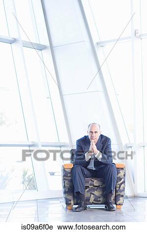 Stock Image - Mature businessman sitting in chair. Fotosearch