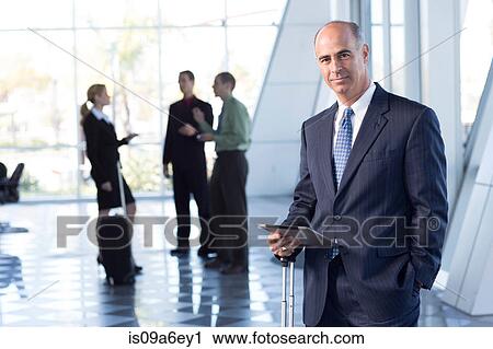 Stock Image - Mature businessman with digital table. Fotosearch