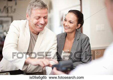 Mature man and mid adult woman at hotel reception View Large Photo Image Stock Image - Mature man and mid adult woman at hotel reception. Fotosearch