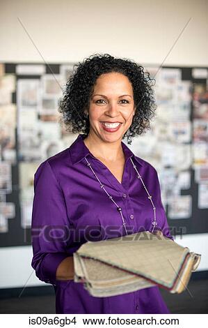 Picture - Mature woman holding textile swatch. Fotosearch