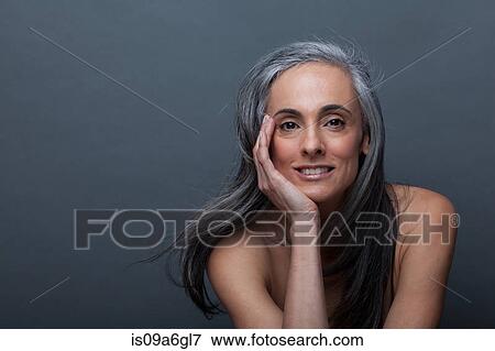 Stock Photo - Mature woman with hand on chin. Fotosearch