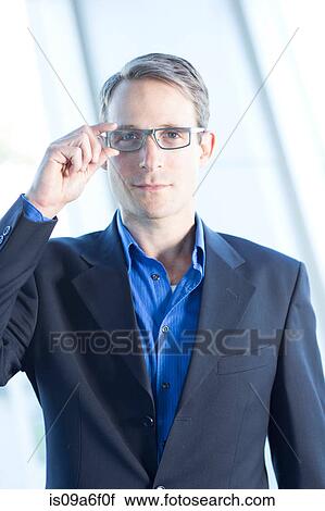 Stock Image - Mid adult businessman wearing glasses. Fotosearch