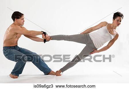 Stock Image - Mid adult couple performing modern dance. Fotosearch
