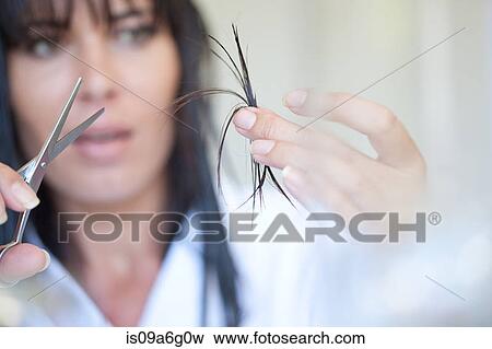 Mid adult woman holding scissors and hair View Large Photo Image Stock Photo - Mid adult woman holding scissors and hair. Fotosearch