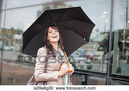 Mid adult woman holding umbrella View Large Photo Image Stock Image - Mid adult woman holding umbrella. Fotosearch