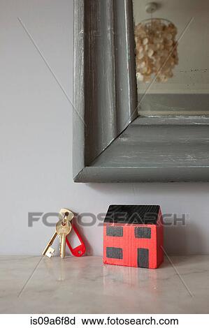 Stock Image - Model of house and keys on mantelpiece. Fotosearch