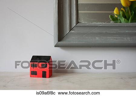 Stock Image - Model of house on mantelpiece. Fotosearch