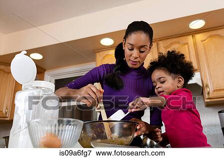 Stock Photo - Mother and daughter baking cookies in kitchen. Fotosearch