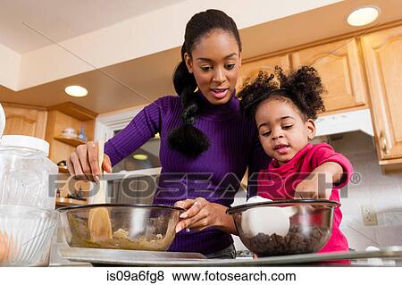 Stock Photo - Mother and daughter mixing cookie dough. Fotosearch