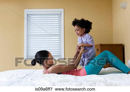 Mother and daughter playing on bed View Large Photo Image Stock Photo - Mother and daughter playing on bed. Fotosearch