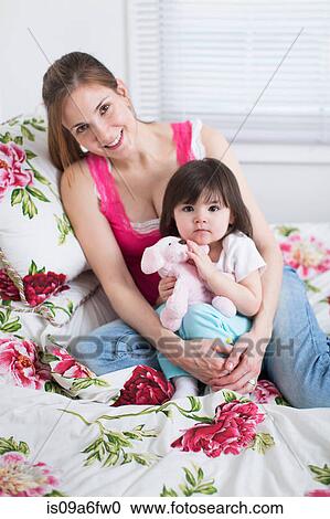 Mother and toddler sitting on bed View Large Photo Image Stock Image - Mother and toddler sitting on bed. Fotosearch