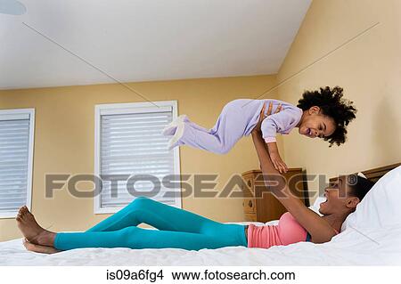 Picture - Mother lifting girl into air. Fotosearch