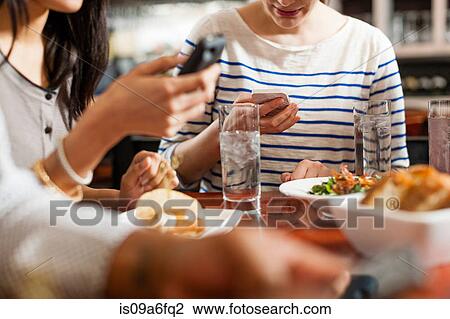 People at restaurant texting View Large Photo Image Stock Image - People at restaurant texting. Fotosearch