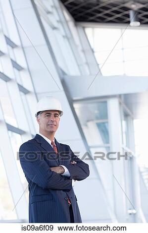 Stock Photo - Portrait of businessman wearing hard hat. Fotosearch