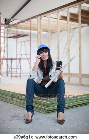 Stock Photo - Portrait of woman holding blueprint on cell phone. Fotosearch