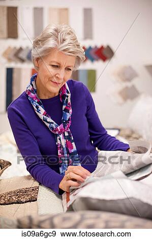 Senior woman choosing textile swatches View Large Photo Image Stock Photo - Senior woman choosing textile swatches. Fotosearch